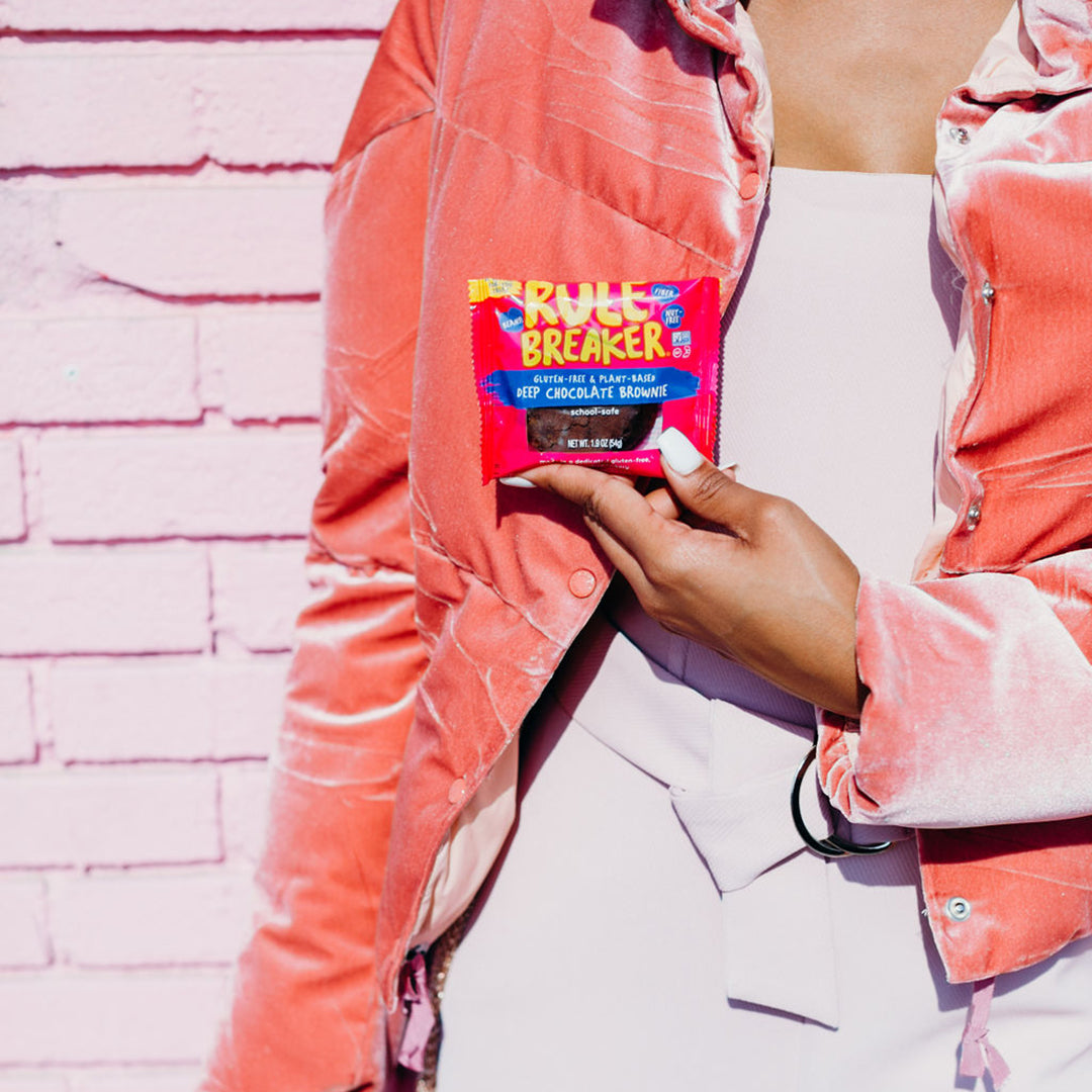 Woman holding Rule Breaker Snacks vegan gluten free allergen free vegan Brownie made with chickpeas