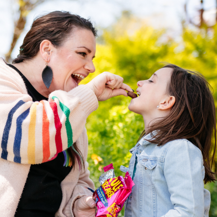 Mom enjoying Rule Breaker Snacks nut free brownies with daughter