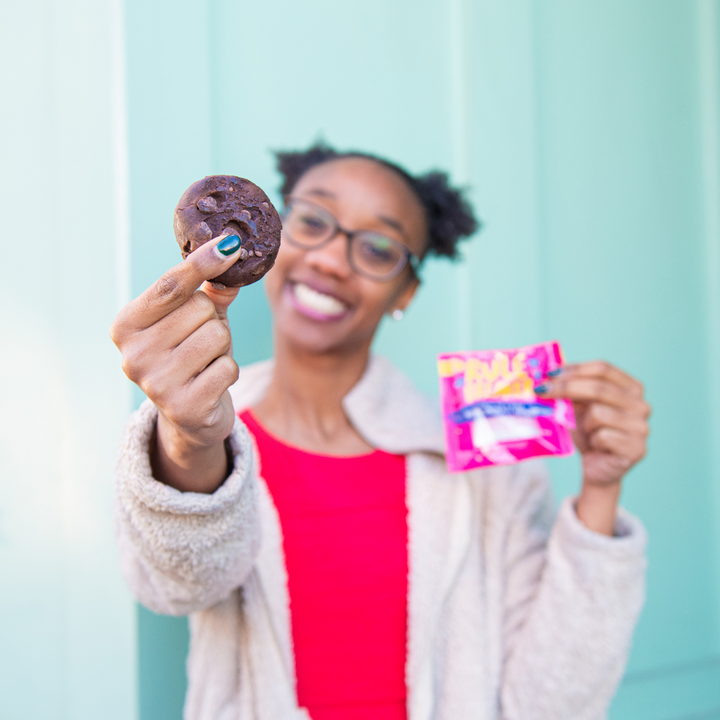 Woman holding Rule Breaker Snacks vegan gluten free allergen free vegan Brownie made with chickpeas