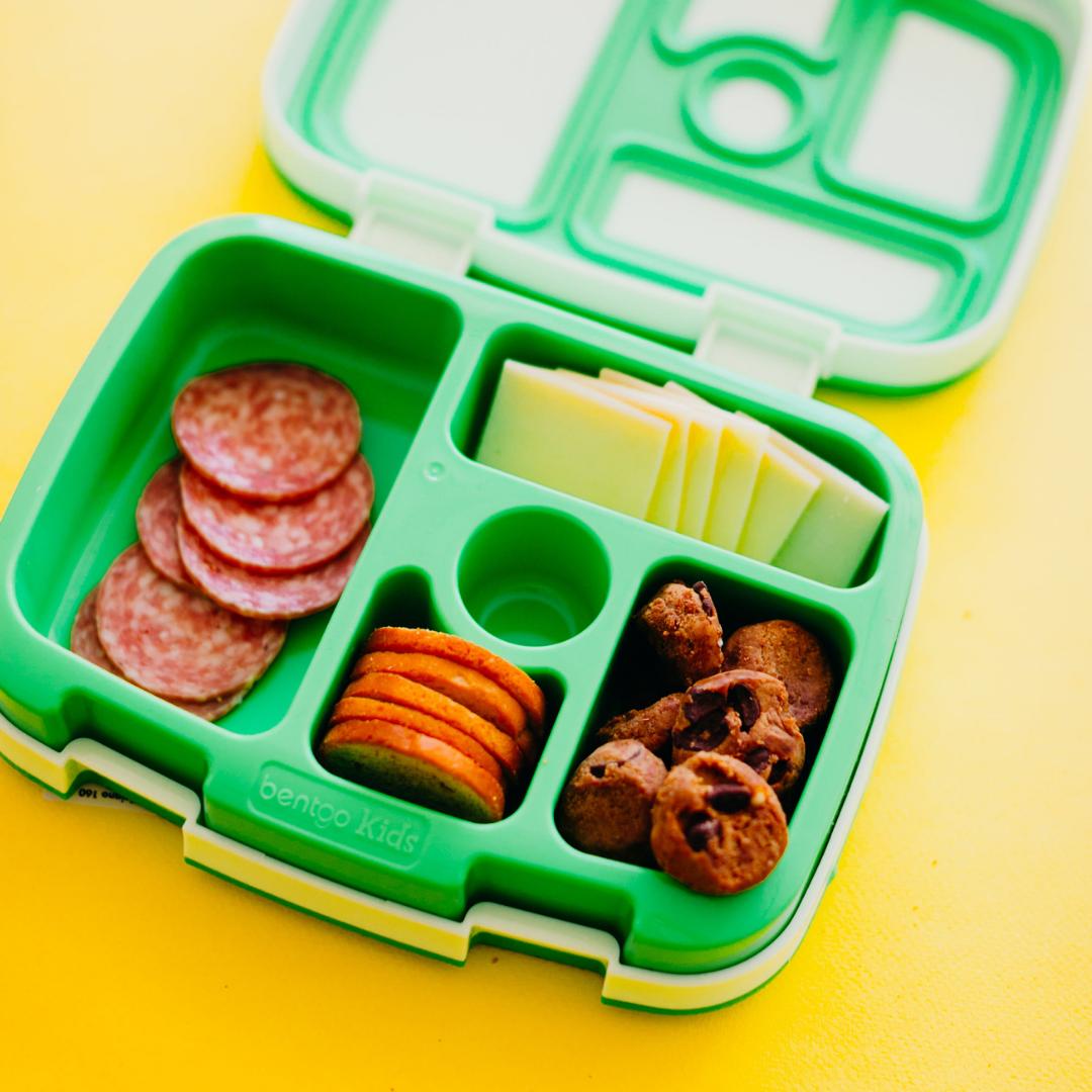 Bento box with Women holding Rule Breaker Snacks Vegan Gluten Free Top 11 Allergen Free Blondie Bites