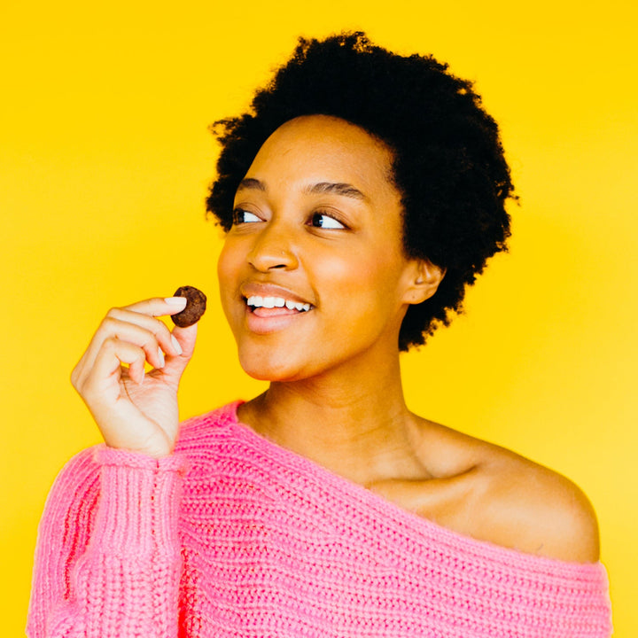 Woman holding vegan Rule Breaker Snacks brownie Bite