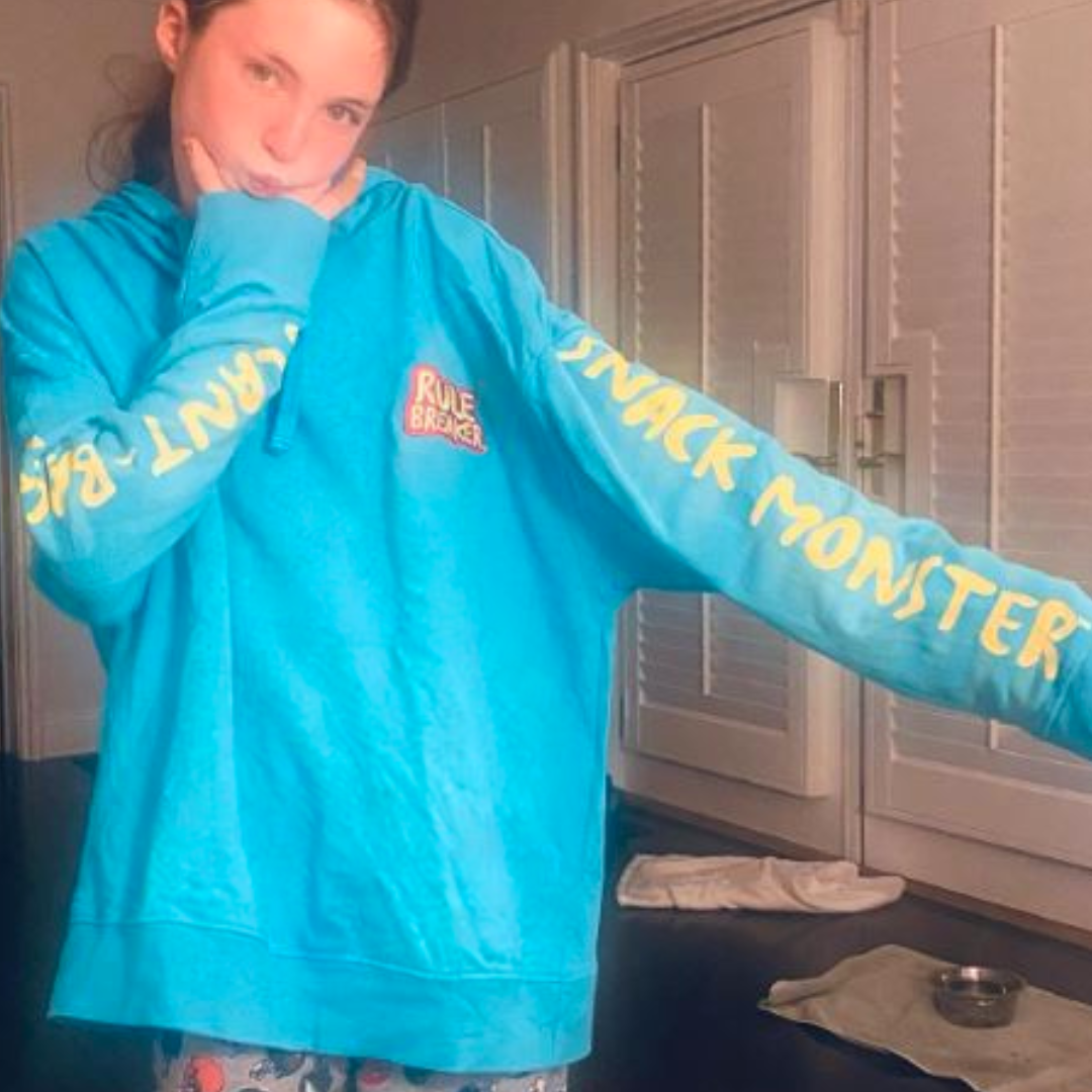 A girl wearing a blue Rule Breaker  Snack Monster hoodie