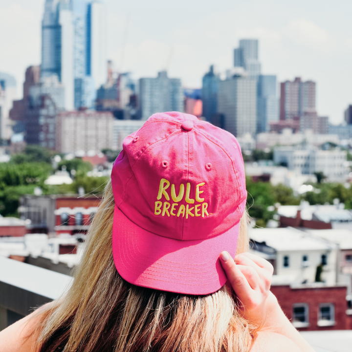 Woman wearing a Rule Breaker hat backwards