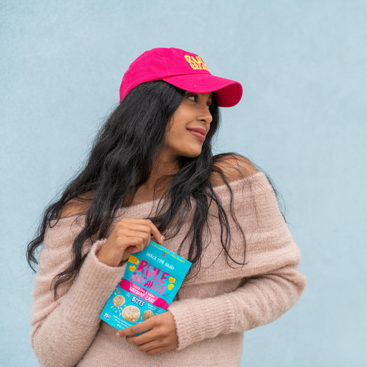 Woman wearing a pink hat with yellow rule breaker logo