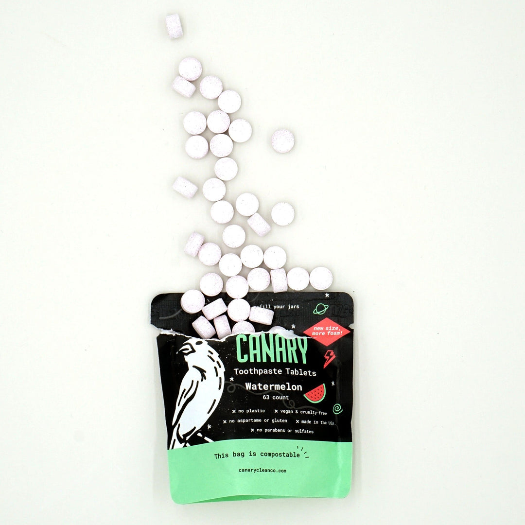 Canary Watermelon Toothpaste Kid-friendly Tablets, sample size 63 count compostable pouch, with tablets spilling out of the open pouch 